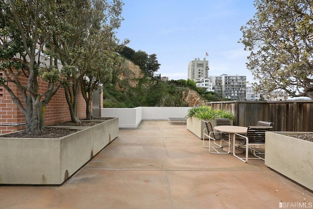 view of patio with a view of city and fence