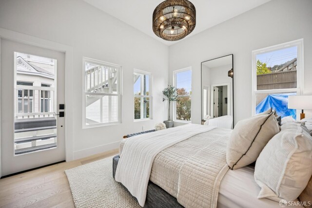 102 Baker St Unit B, San Francisco, CA 94117 - bedroom with multiple windows, wood finished floors, and a chandelier