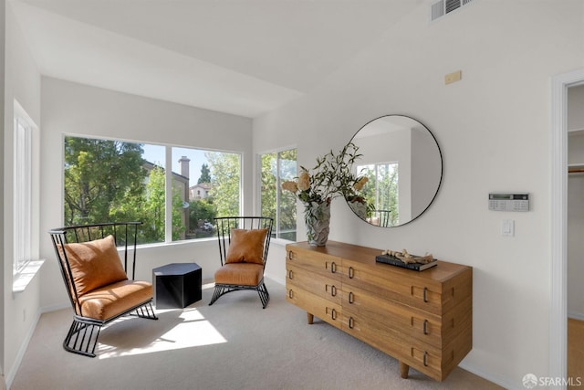 living area featuring carpet, visible vents, and baseboards