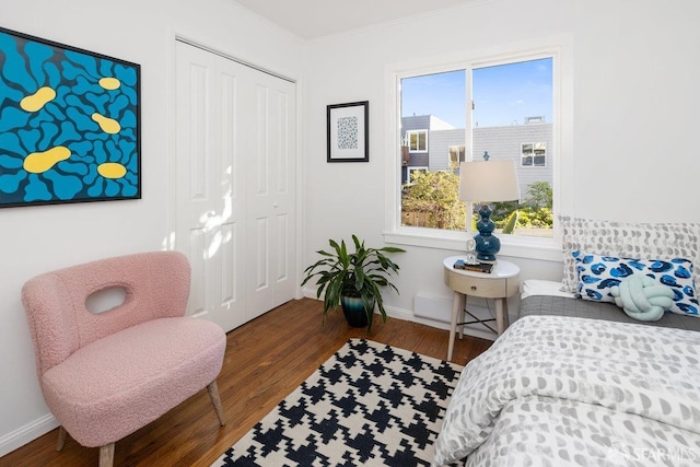 bedroom featuring crown molding, hardwood / wood-style flooring, and a closet