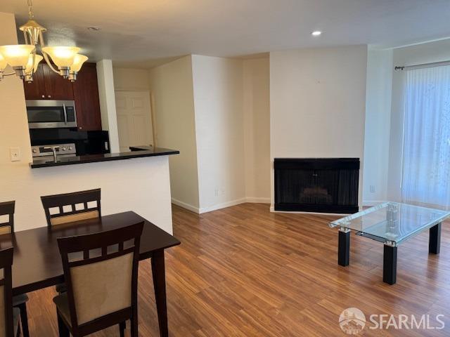 397 Imperial Way Unit 306, Daly City, CA 94015 - dining room with wood finished floors, a fireplace, baseboards, recessed lighting, and a chandelier
