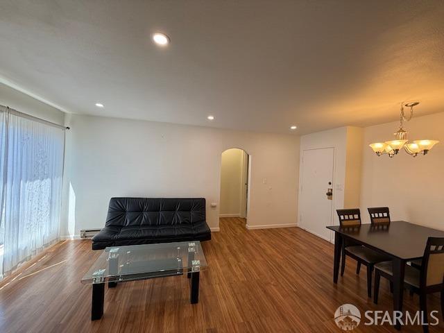 397 Imperial Way Unit 306, Daly City, CA 94015 - sitting room with an inviting chandelier, arched walkways, recessed lighting, wood finished floors, and a baseboard radiator