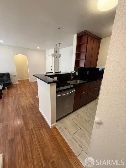 397 Imperial Way Unit 306, Daly City, CA 94015 - kitchen with dark countertops, arched walkways, stainless steel dishwasher, open shelves, and a sink