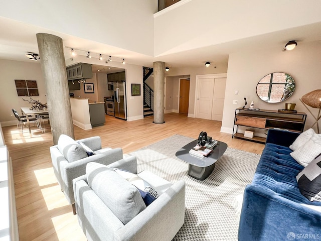 1 Bluxome St Unit 317, San Francisco, CA 94107 - living room featuring ornate columns, stairway, and light wood-type flooring