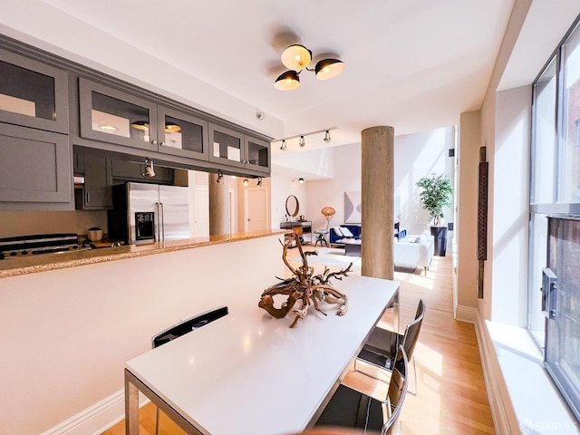 1 Bluxome St Unit 317, San Francisco, CA 94107 - kitchen featuring stainless steel fridge with ice dispenser, light wood-style floors, glass insert cabinets, and a kitchen bar