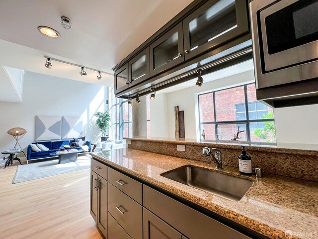 1 Bluxome St Unit 317, San Francisco, CA 94107 - kitchen featuring track lighting, light stone countertops, light wood-type flooring, and stainless steel microwave