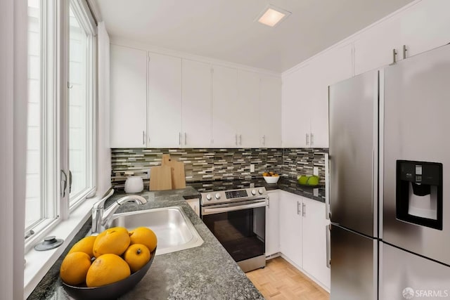 kitchen with white cabinetry, appliances with stainless steel finishes, and dark countertops
