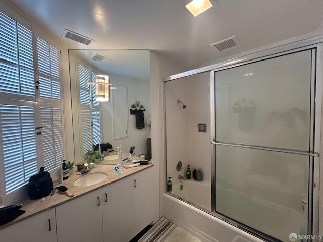 full bath with enclosed tub / shower combo, visible vents, and vanity