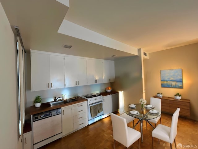 kitchen featuring white cabinets, dark countertops, a sink, white appliances, and visible vents
