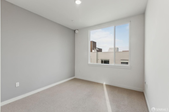 spare room with baseboards and carpet flooring