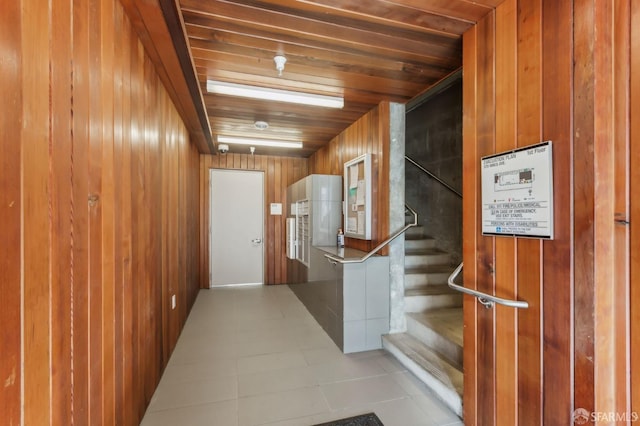 hallway featuring wooden ceiling and wood walls