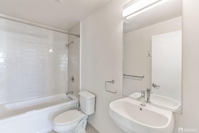 full bathroom featuring tiled shower / bath, toilet, and sink