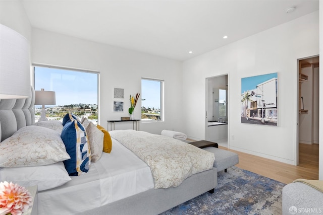 bedroom with hardwood / wood-style flooring and ensuite bathroom