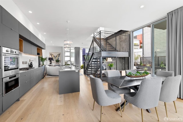 dining area with floor to ceiling windows and light hardwood / wood-style floors