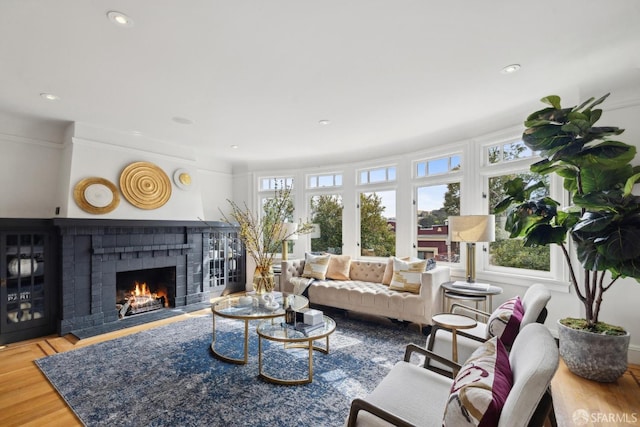 living area with a fireplace, wood finished floors, and recessed lighting