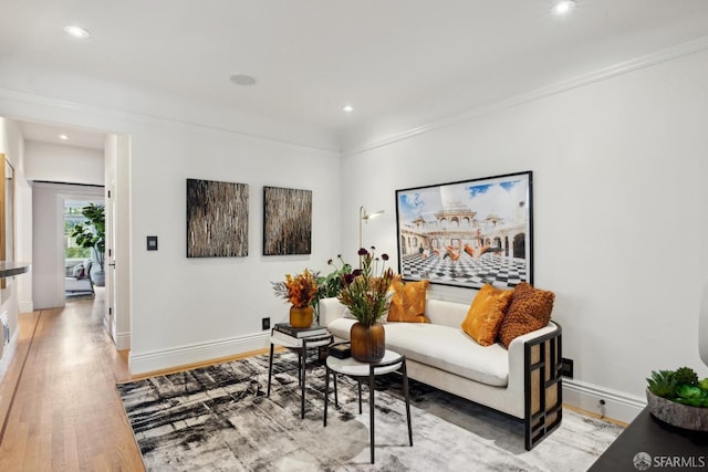 sitting room with recessed lighting, crown molding, light wood-style flooring, and baseboards