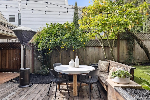 deck with a fenced backyard and outdoor dining area