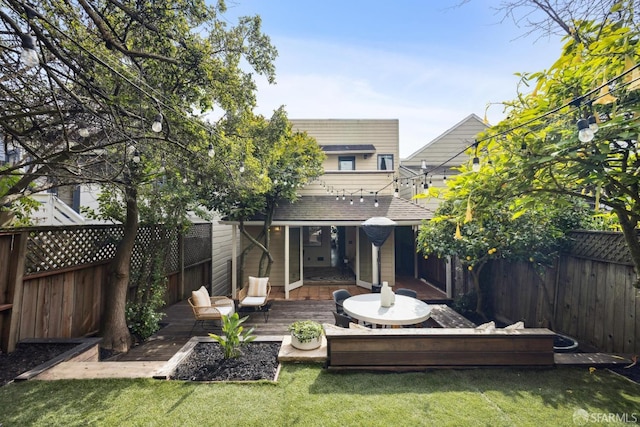 back of house with a yard, a fenced backyard, and a wooden deck