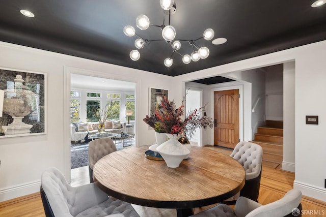 dining area with stairs, light wood-style flooring, and baseboards