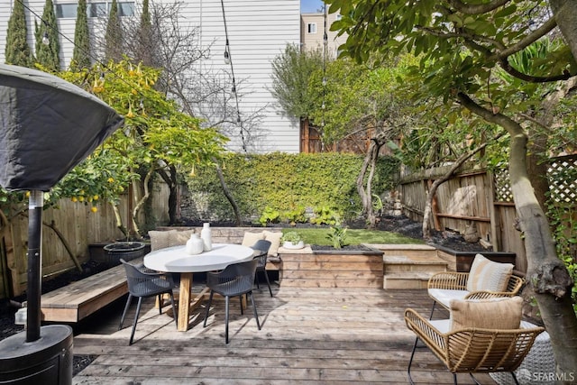 deck with a fenced backyard and outdoor dining space