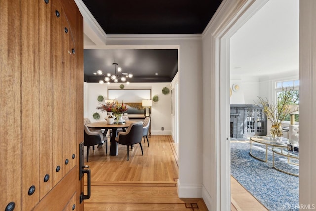 interior space with ornamental molding, wood finished floors, and baseboards