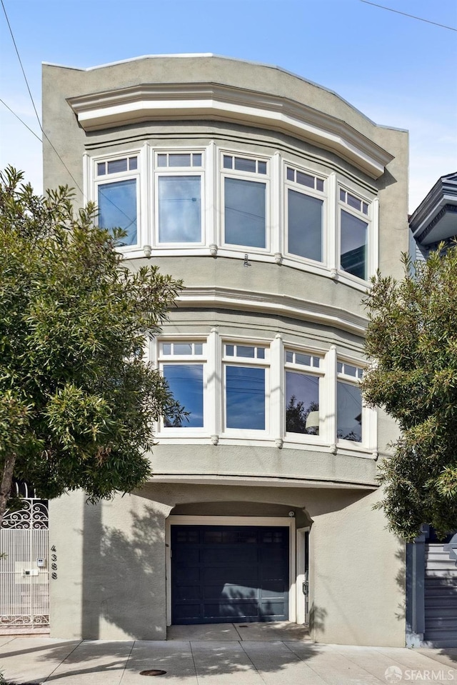 view of side of property featuring a garage and stucco siding