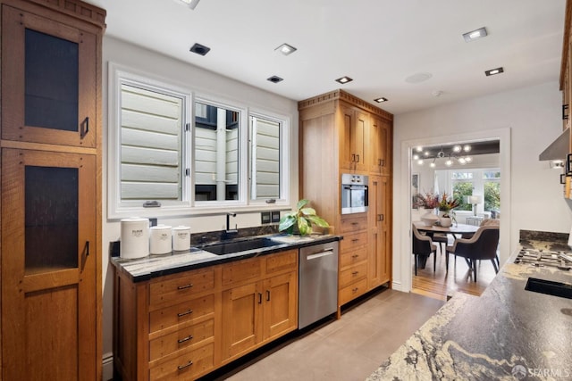 kitchen with appliances with stainless steel finishes, brown cabinets, and a sink