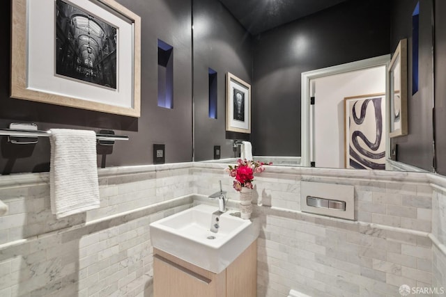 bathroom with a wainscoted wall, vanity, and tile walls