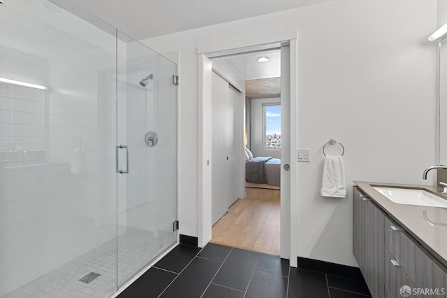 full bath with connected bathroom, vanity, a shower stall, baseboards, and tile patterned floors