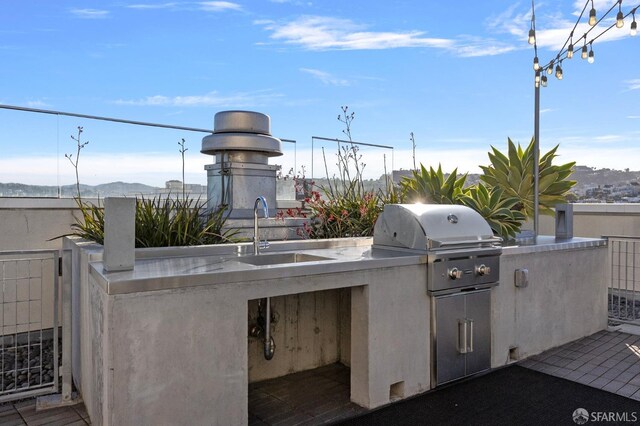 view of patio / terrace with area for grilling, a sink, a mountain view, and a grill