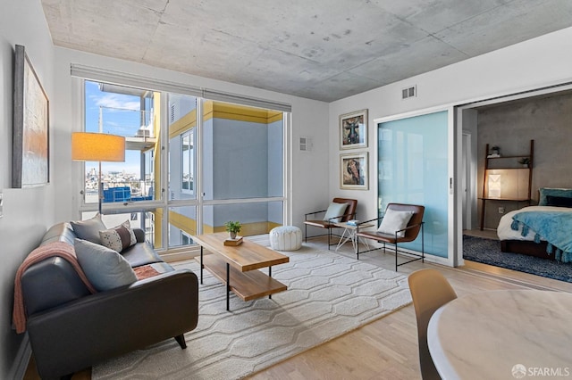 living area featuring visible vents and wood finished floors