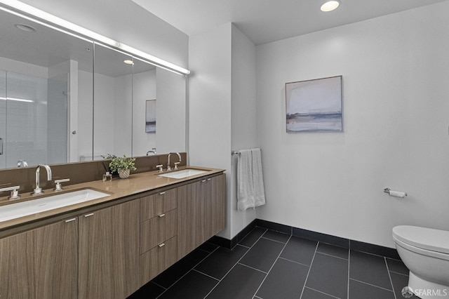 full bath featuring toilet, tile patterned flooring, baseboards, and a sink