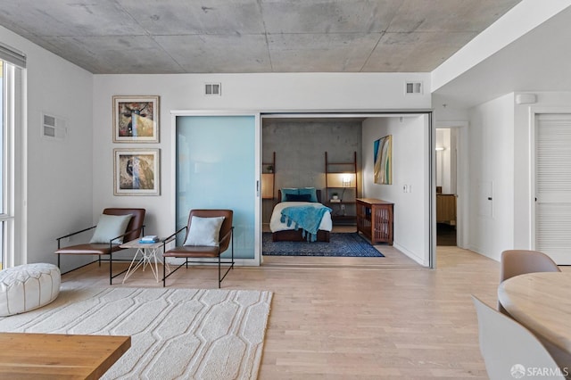 bedroom with a closet, visible vents, and wood finished floors