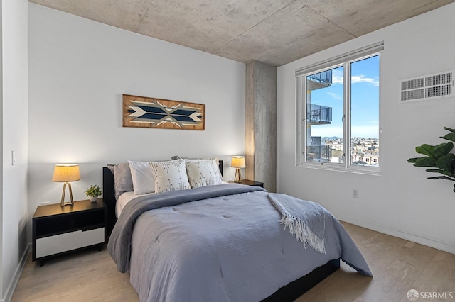 bedroom featuring light wood-style floors, visible vents, and baseboards