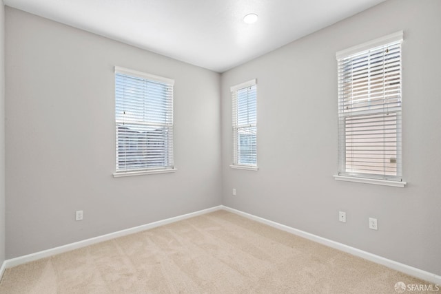 spare room featuring light colored carpet