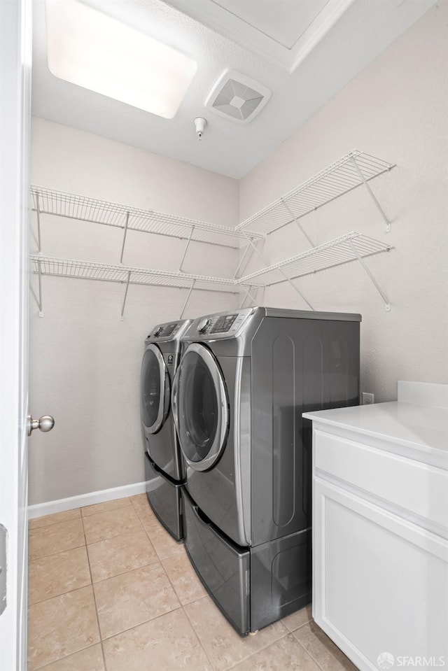 laundry room with cabinets, independent washer and dryer, and light tile patterned floors