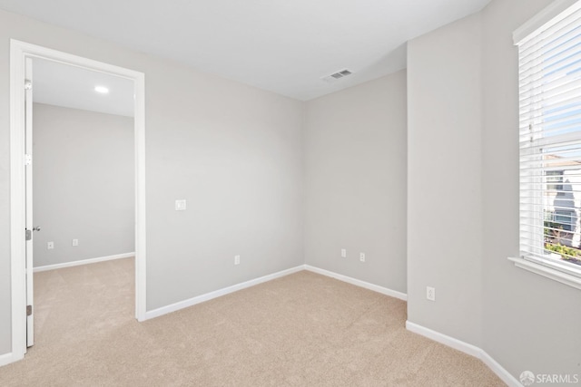 unfurnished room featuring light carpet