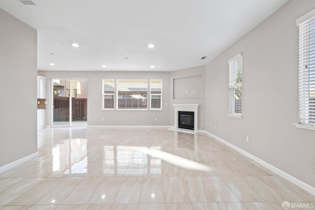 unfurnished living room featuring a wealth of natural light and light tile patterned floors