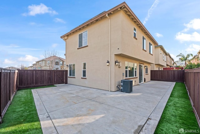 rear view of house with a patio, a yard, and central AC