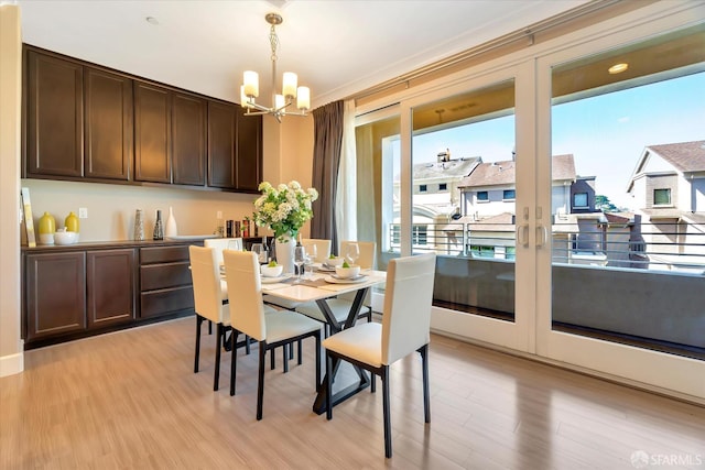 dining space with a chandelier, a wealth of natural light, and light hardwood / wood-style flooring