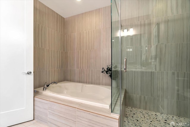 bathroom featuring separate shower and tub and tile walls