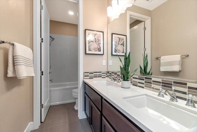 full bathroom with backsplash, toilet, vanity, and shower / washtub combination