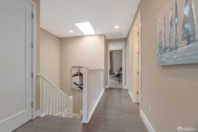 hallway with hardwood / wood-style floors and a skylight