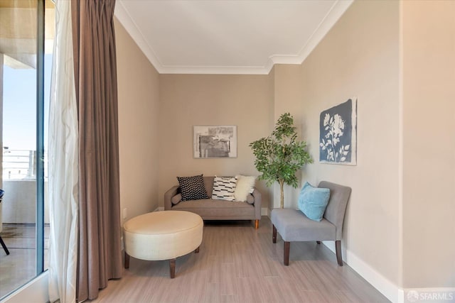 living area with hardwood / wood-style floors and crown molding