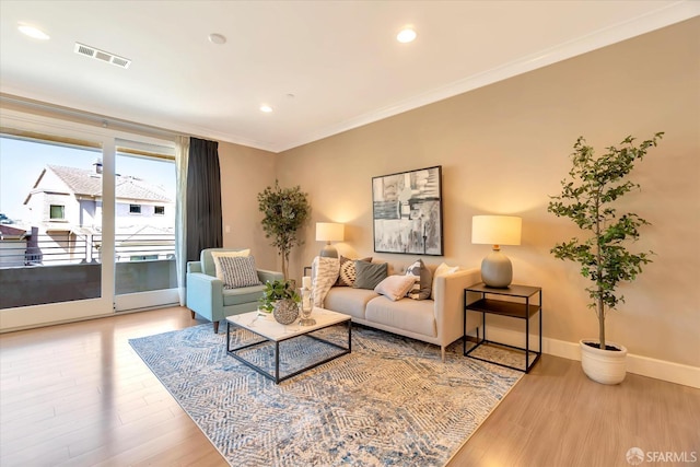 living room with light hardwood / wood-style floors and ornamental molding