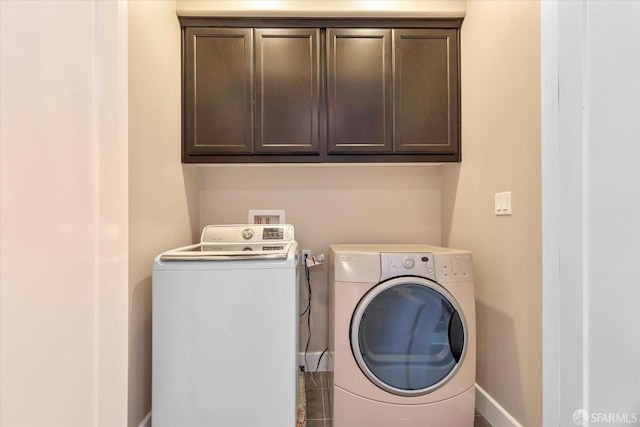 laundry area featuring washer and dryer and cabinets