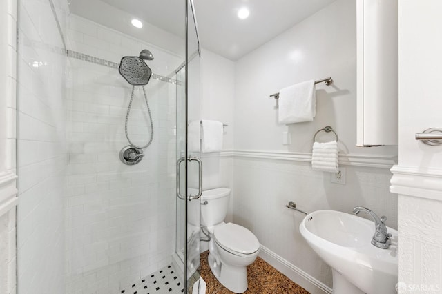 bathroom with sink, toilet, and a shower with shower door