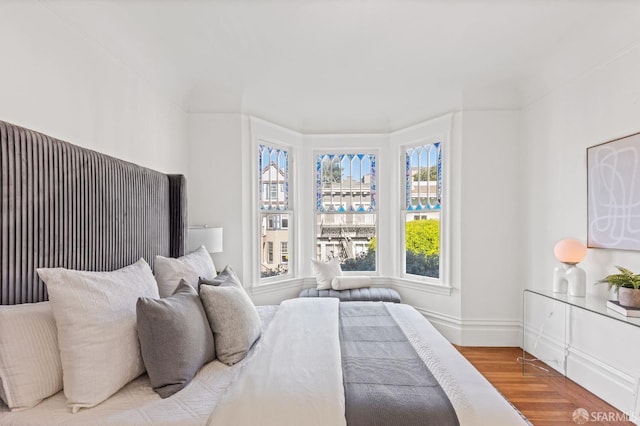 bedroom featuring wood-type flooring and ornamental molding