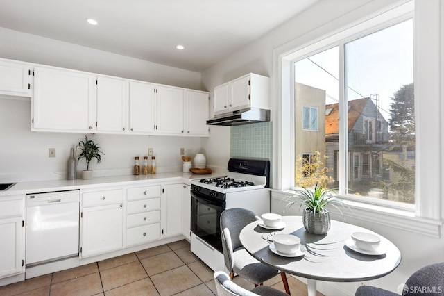 kitchen featuring white cabinets, tasteful backsplash, white appliances, and light tile patterned floors