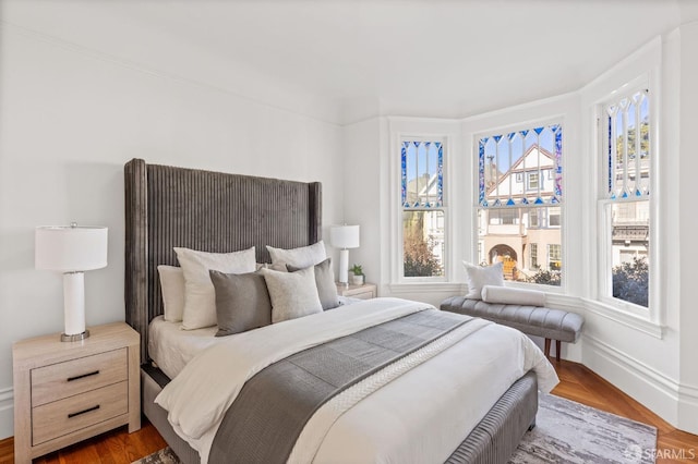 bedroom featuring multiple windows and dark hardwood / wood-style flooring